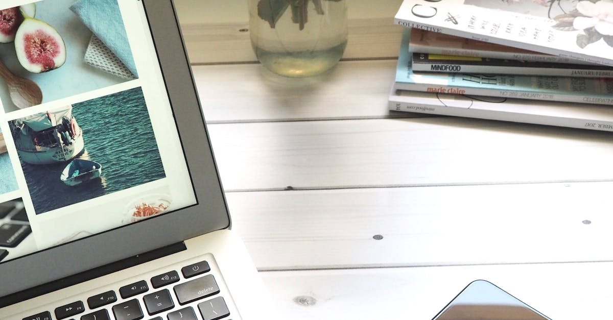 Elegant workspace featuring a laptop, smartphone, and fresh roses in a bright setting.